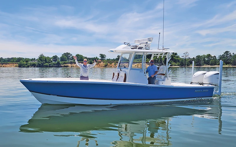 Front view of the Regulator 30XO gliding through calm waters with two passengers, highlighting its sleek design and performance