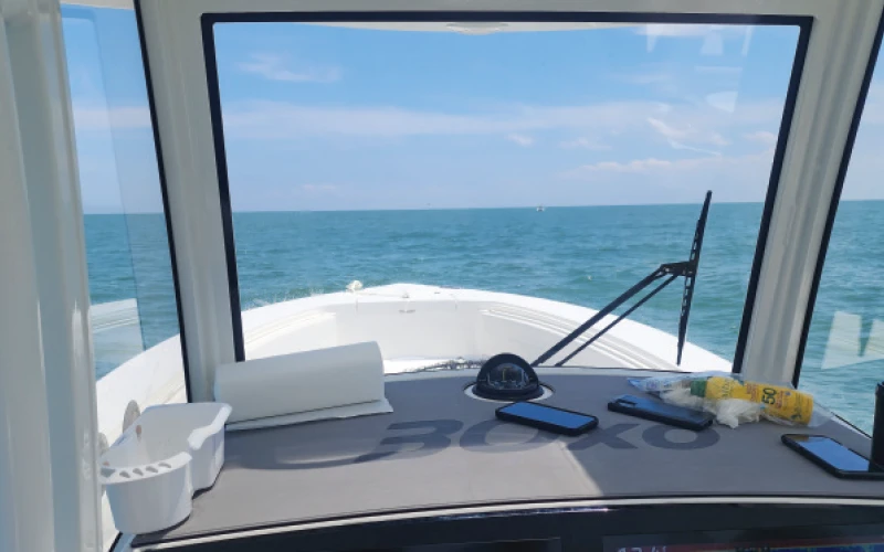 Helm view from inside the Regulator 30XO, showcasing the forward visibility and control setup for navigating open waters